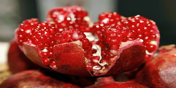 beneficios de la granada Granada abierta mostrando sus semillas rojas ricas en antioxidantes y nutrientes.